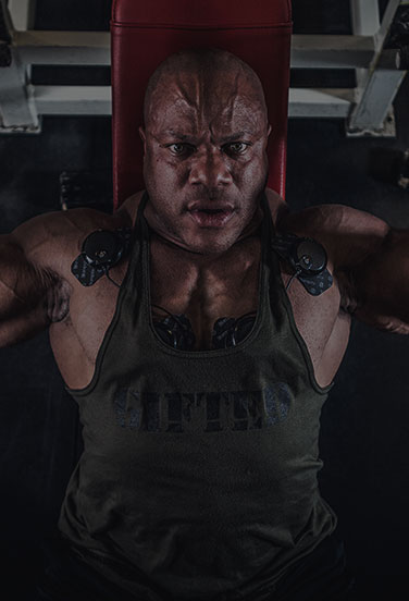 Phil Heath lifting weights while using wireless usa muscle stim