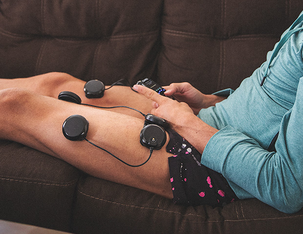 Running using muscle stimulator to recover on the couch