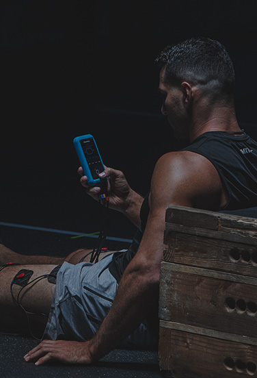 soccer player using musle stimulator to recover