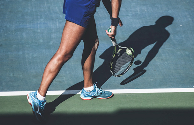 tennis player bouncing tennis ball